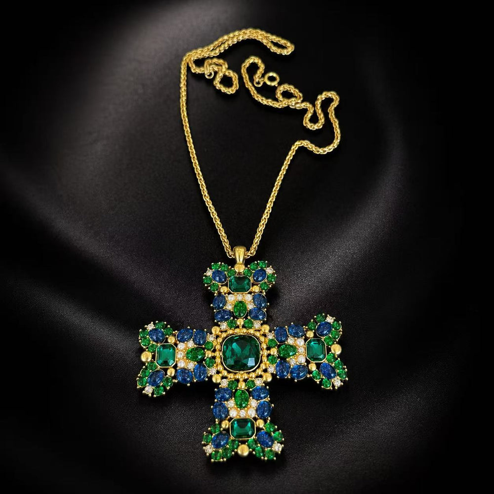 Gold-tone green and blue glass cross brooch pendant necklace on black background