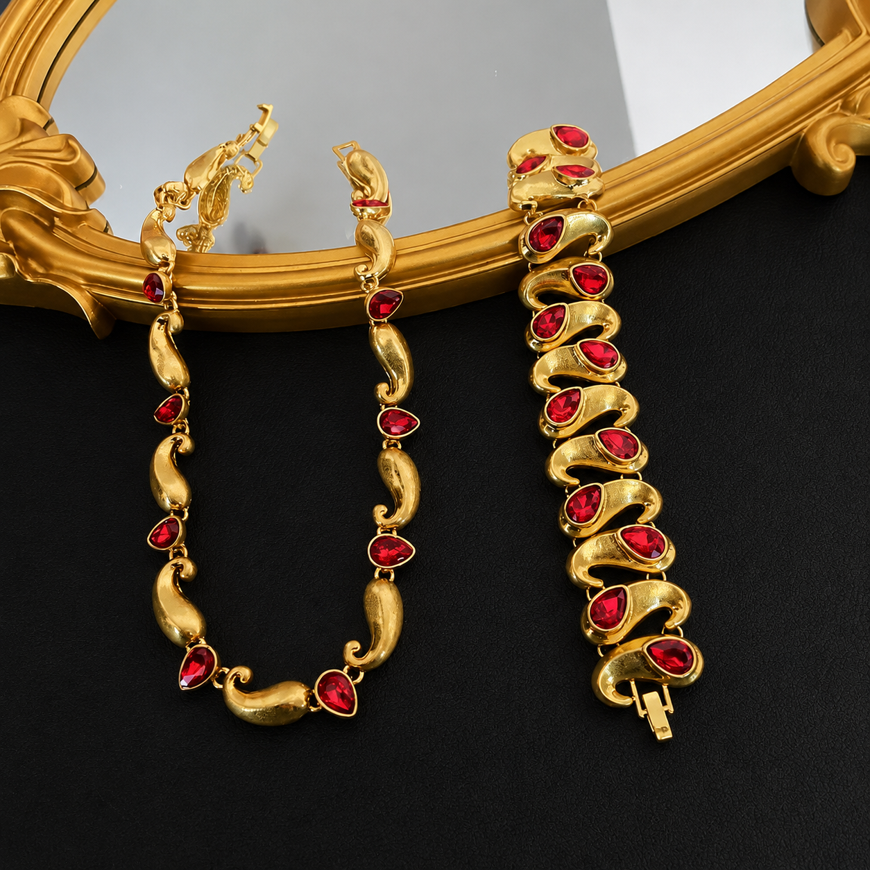 Gold-tone necklace and bracelet set with red faceted teardrop-shaped accents