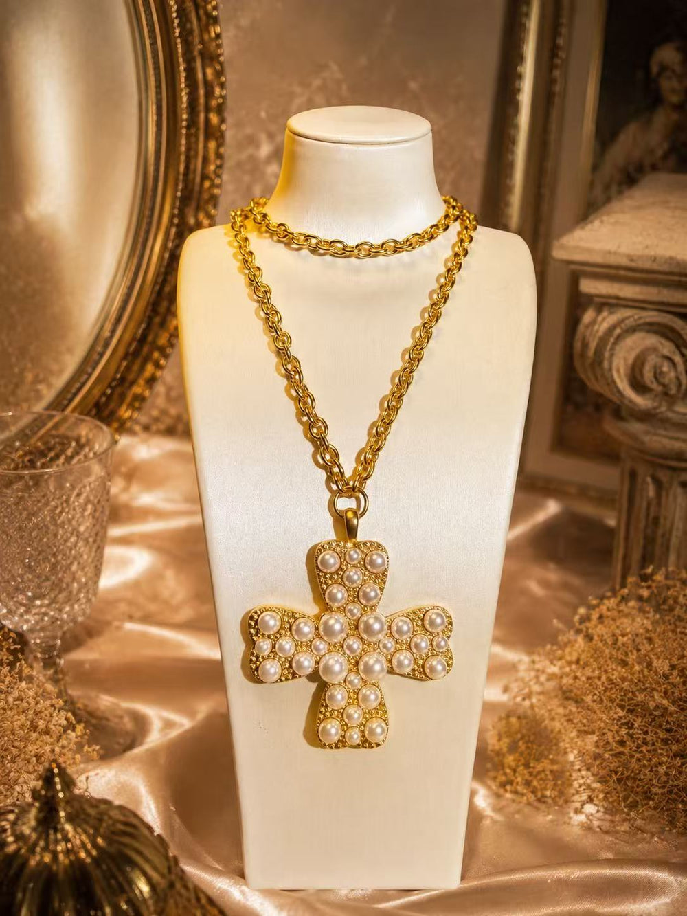 Front view of the gold-tone cross pendant necklace with white pearl-style beads