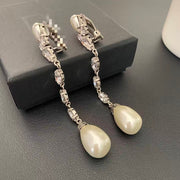 Angled detail of the long pearl-style drop clip-on earrings