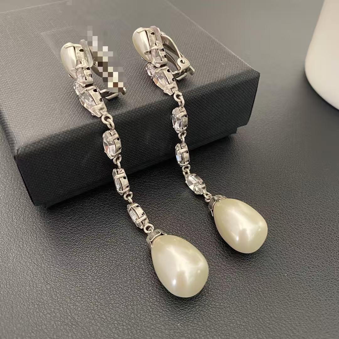 Angled detail of the long pearl-style drop clip-on earrings