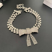 Silver-tone bow choker necklace with three rows of clear faceted stones and dangling bow tails, front view