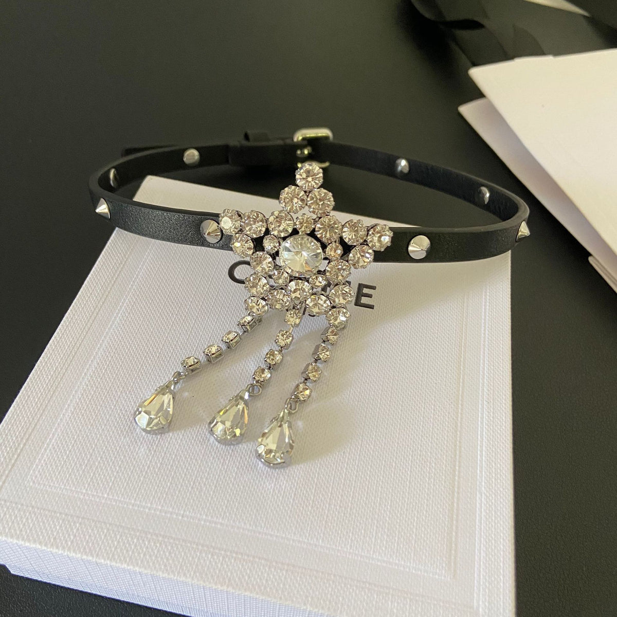 Angled view of the sparkling star choker with its black band and adjustable buckle