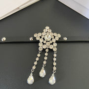 Close-up of the five-point star centrepiece and three clear faceted teardrop tassels