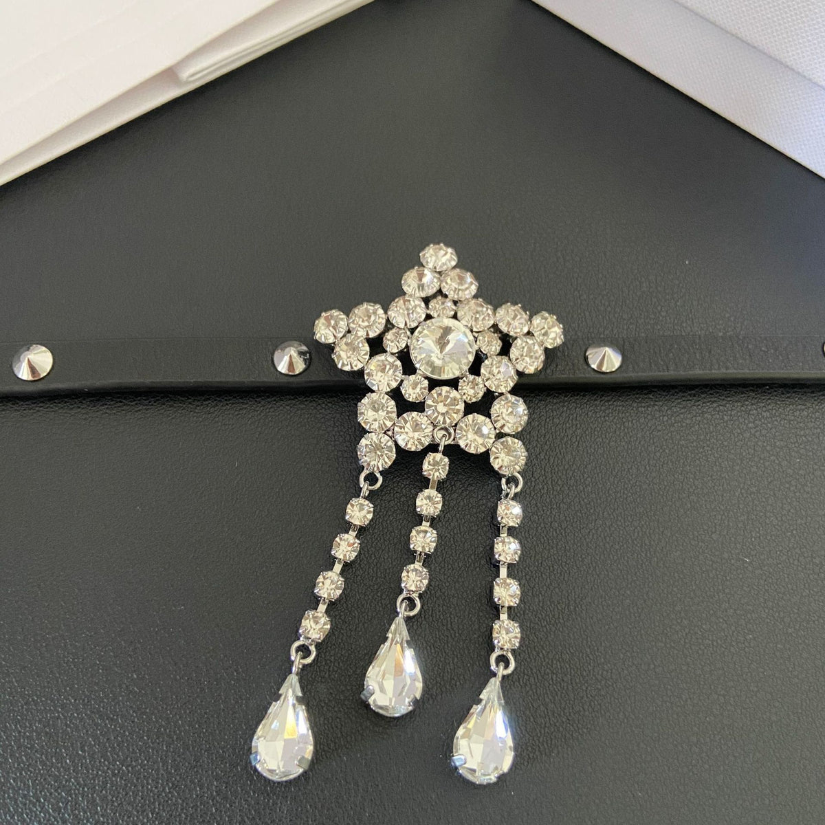 Close-up of the five-point star centrepiece and three clear faceted teardrop tassels