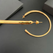 Close view of the post-back closure on an oversized gold-tone hoop earring