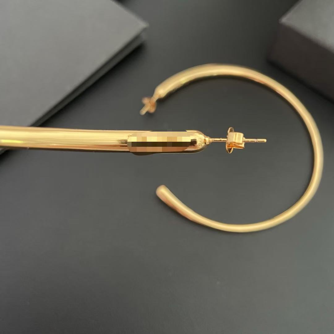 Close view of the post-back closure on an oversized gold-tone hoop earring