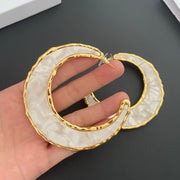 Pair of oversized gold-tone moon stud earrings with pearlescent inlay