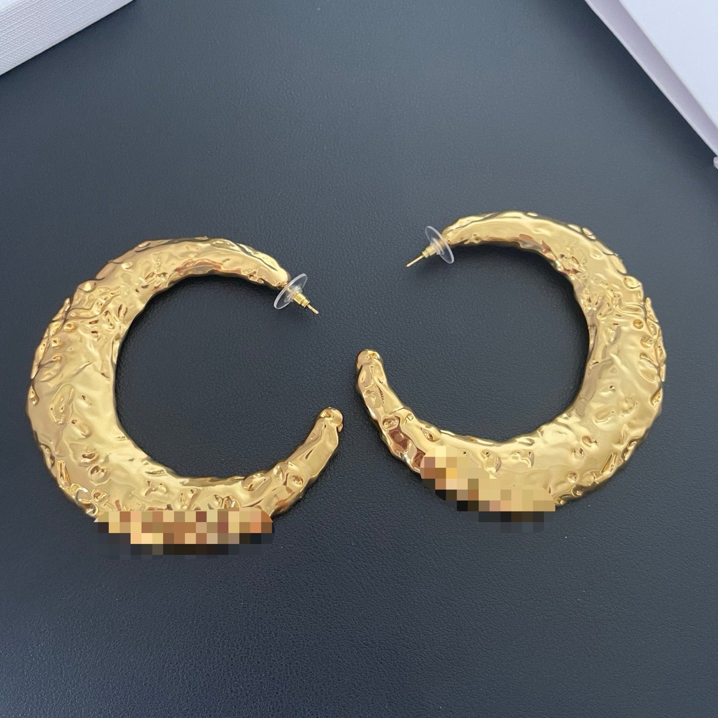 Back view of gold-tone moon statement earrings showing textured finish and post backs