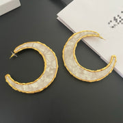 Pair of gold-tone moon statement stud earrings with pearlescent crescent inlay