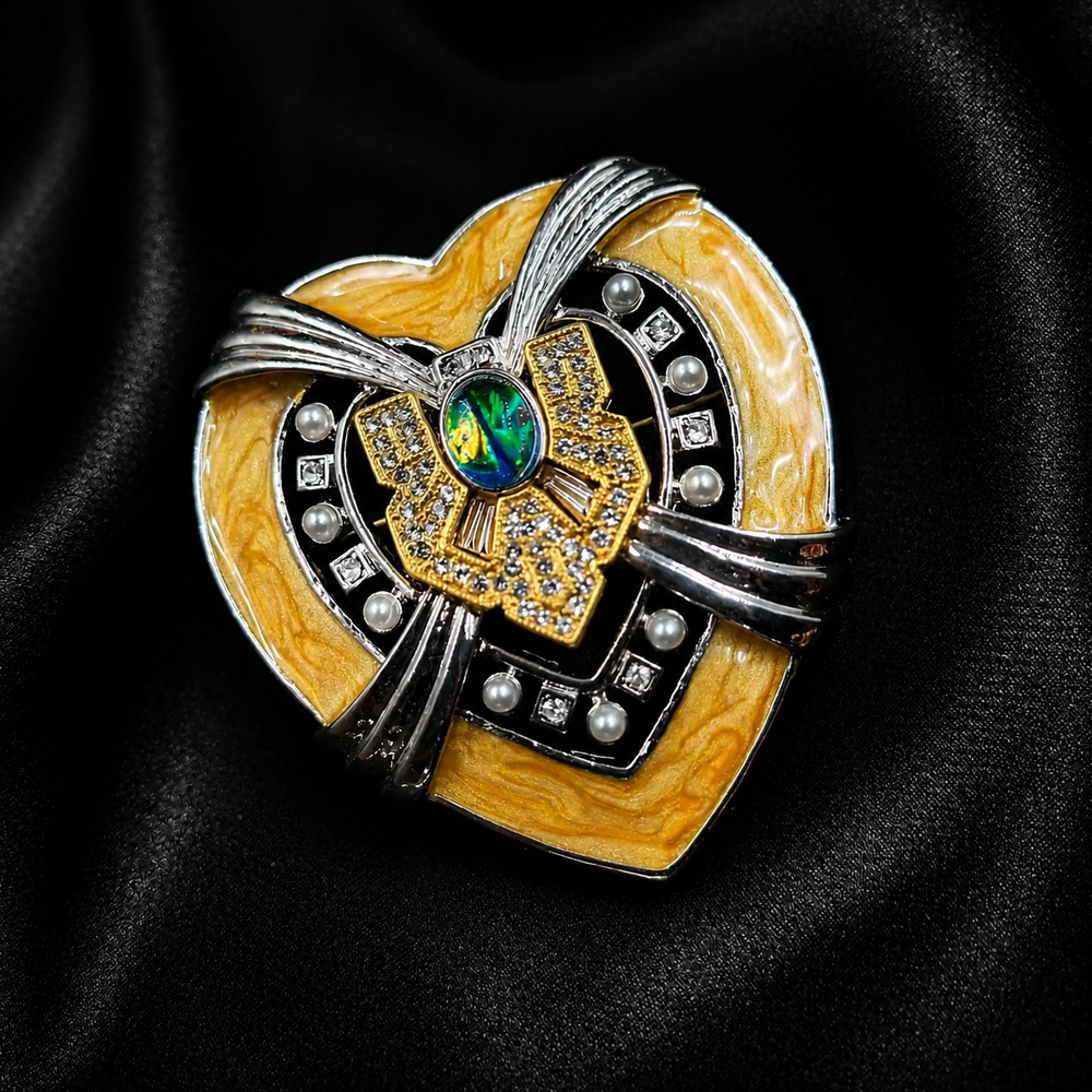 Abstract bow brooch with yellow marbled accents, pearl-style beads, crystal-style details, and a green center accent