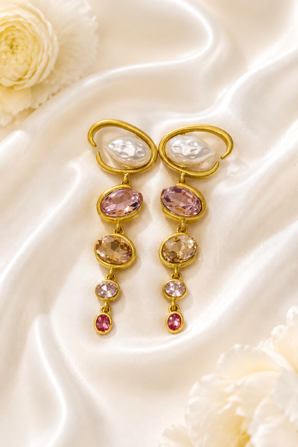 Baroque-inspired light pink rhinestone-style earrings on cream satin