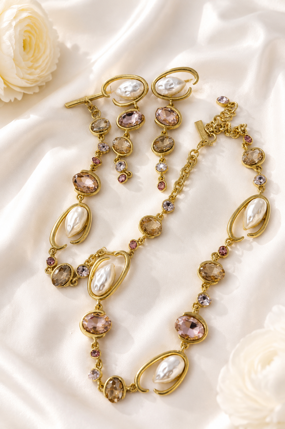 Baroque-inspired light pink rhinestone-style jewelry set on cream satin