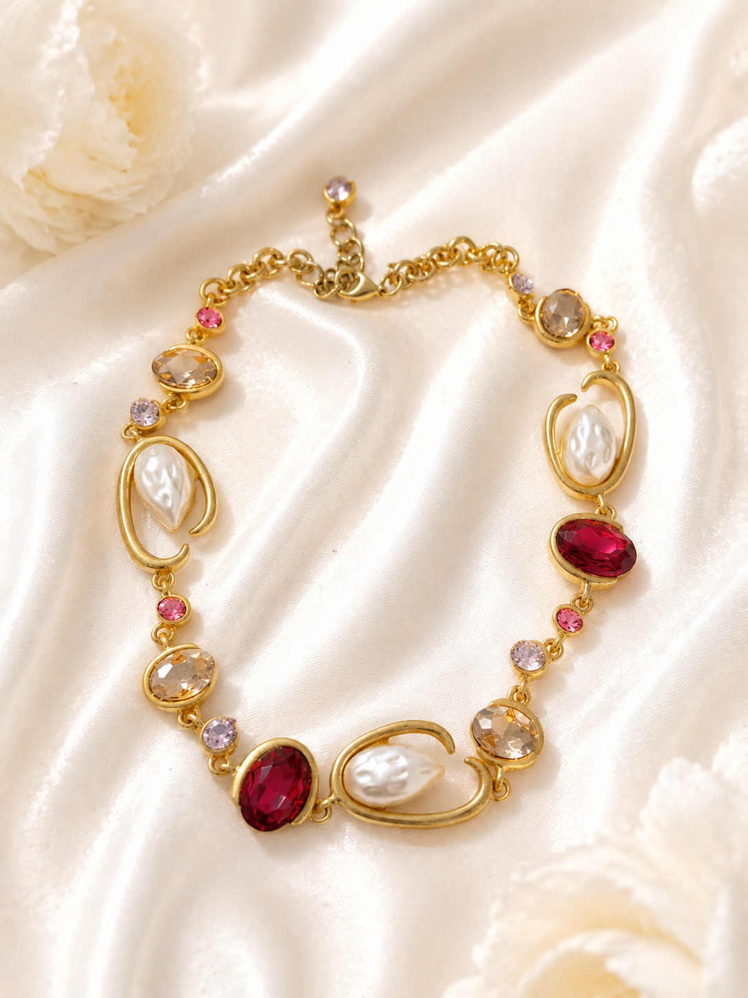 Baroque-inspired magenta rhinestone-style necklace on cream satin