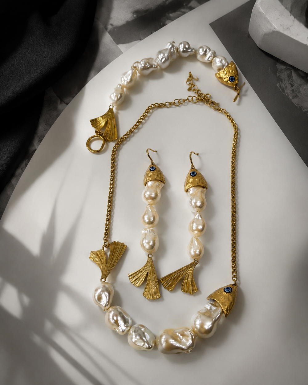 Gold-tone pearl-style earrings with blue details and fan-shaped charms