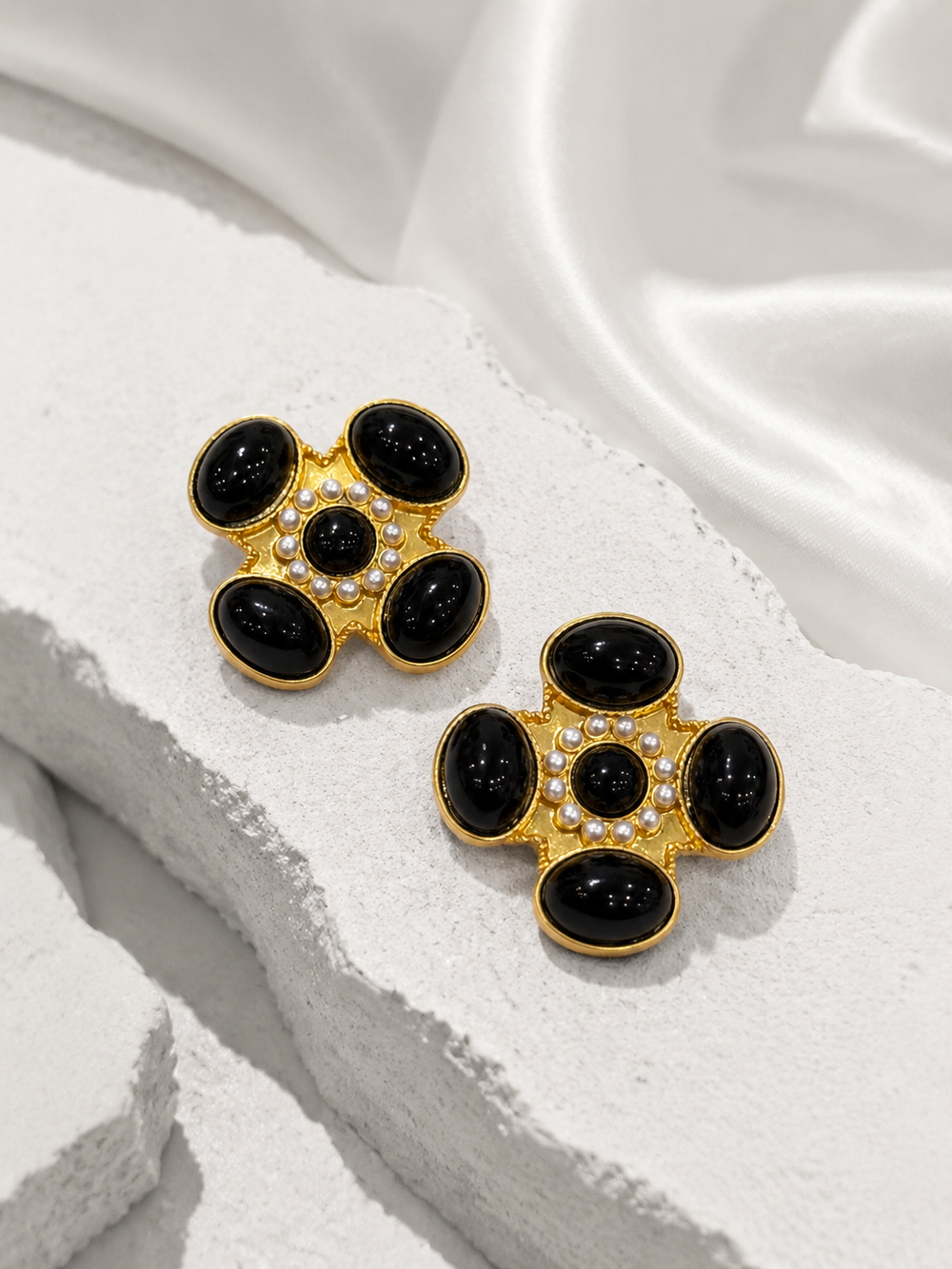 Black floral cross-inspired statement stud earrings, front view
