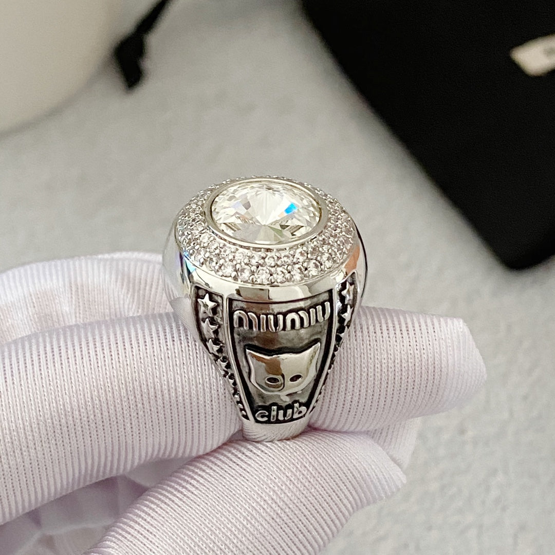Side detail of silver-tone cat motif ring with clear faceted center accent