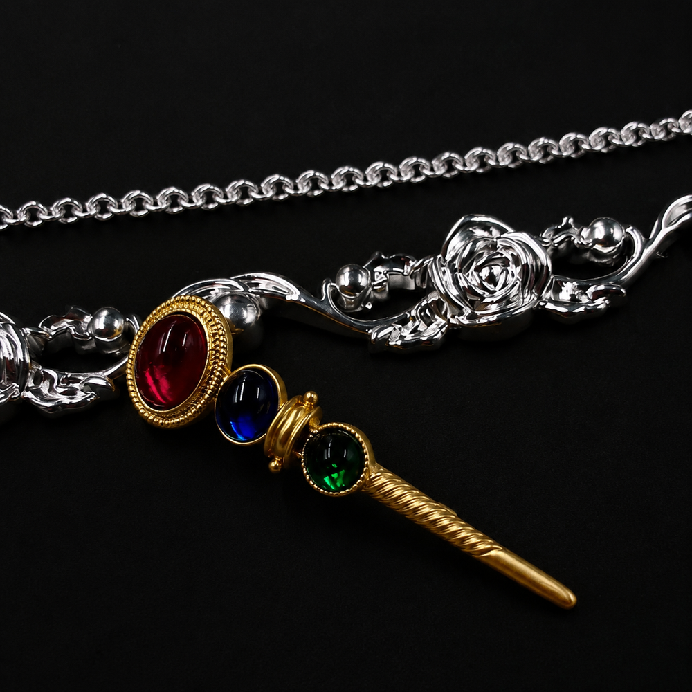 Colorful glass-style wand brooch with red, blue, and green accents, front view
