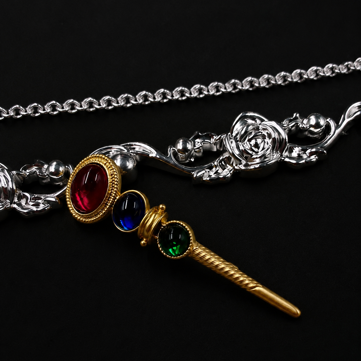 Colorful glass-style wand brooch with red, blue, and green accents, front view