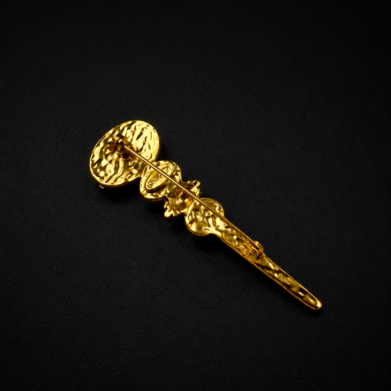 Colorful glass-style wand brooch showing the pin-back fastening