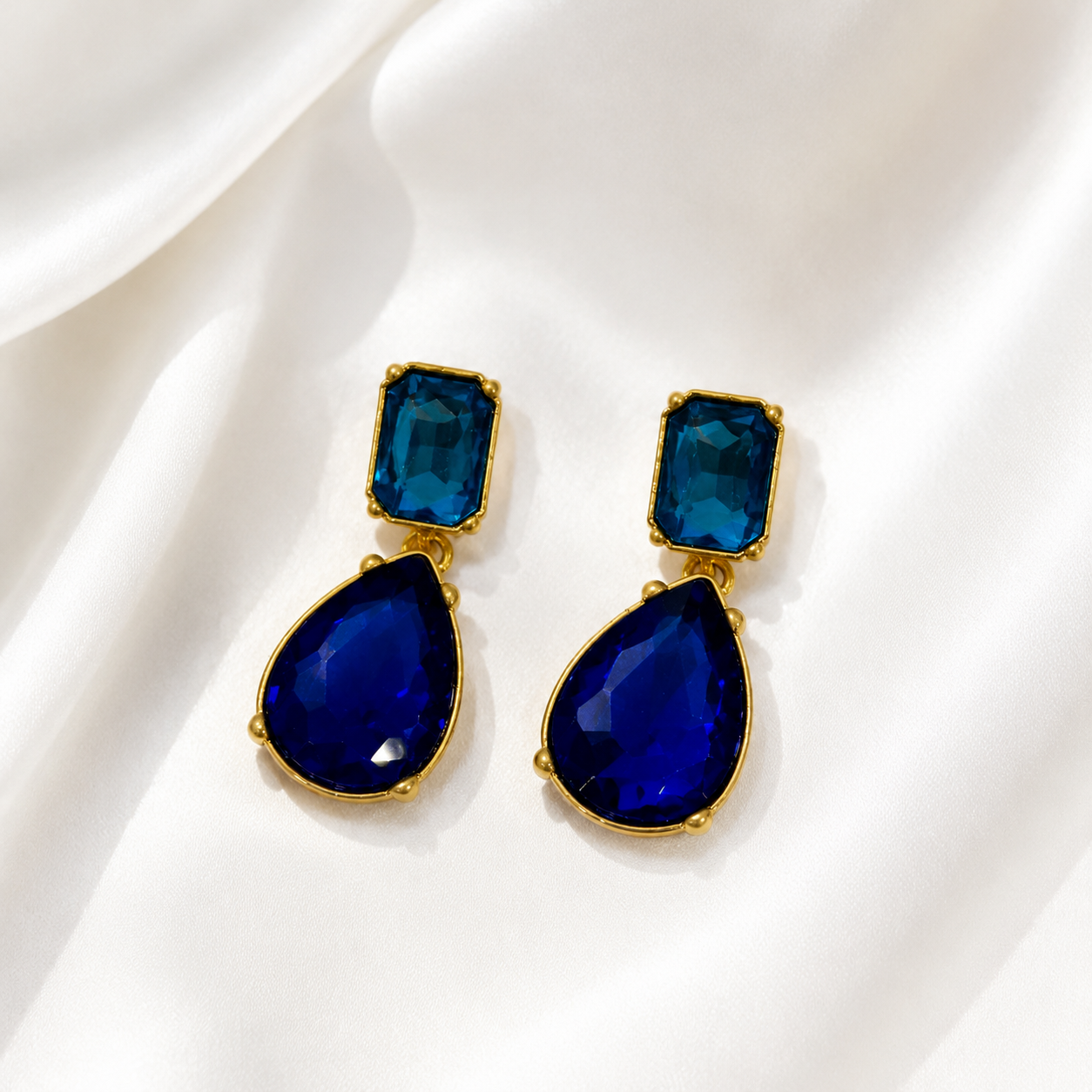 Blue crystal-style teardrop drop stud earrings with gold-tone settings