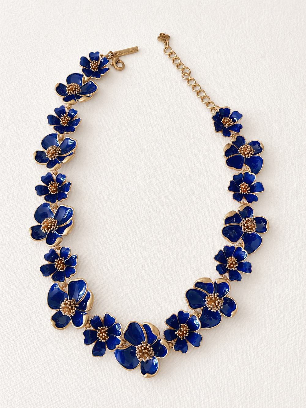 Deep blue enamel floral necklace on ivory fabric