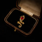Gold-tone adjustable ring with red glass cabochon-style centerpiece angled view in vintage jewelry box