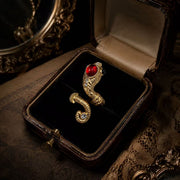 Gold-tone adjustable ring with red glass cabochon-style centerpiece in vintage jewelry box
