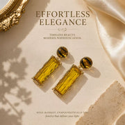 Gold-tone amber glass-style rectangular drop stud earrings flat lay