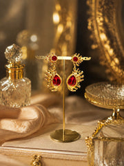 Gold-tone Barbie pink red crystal-style teardrop stud earrings on display stand