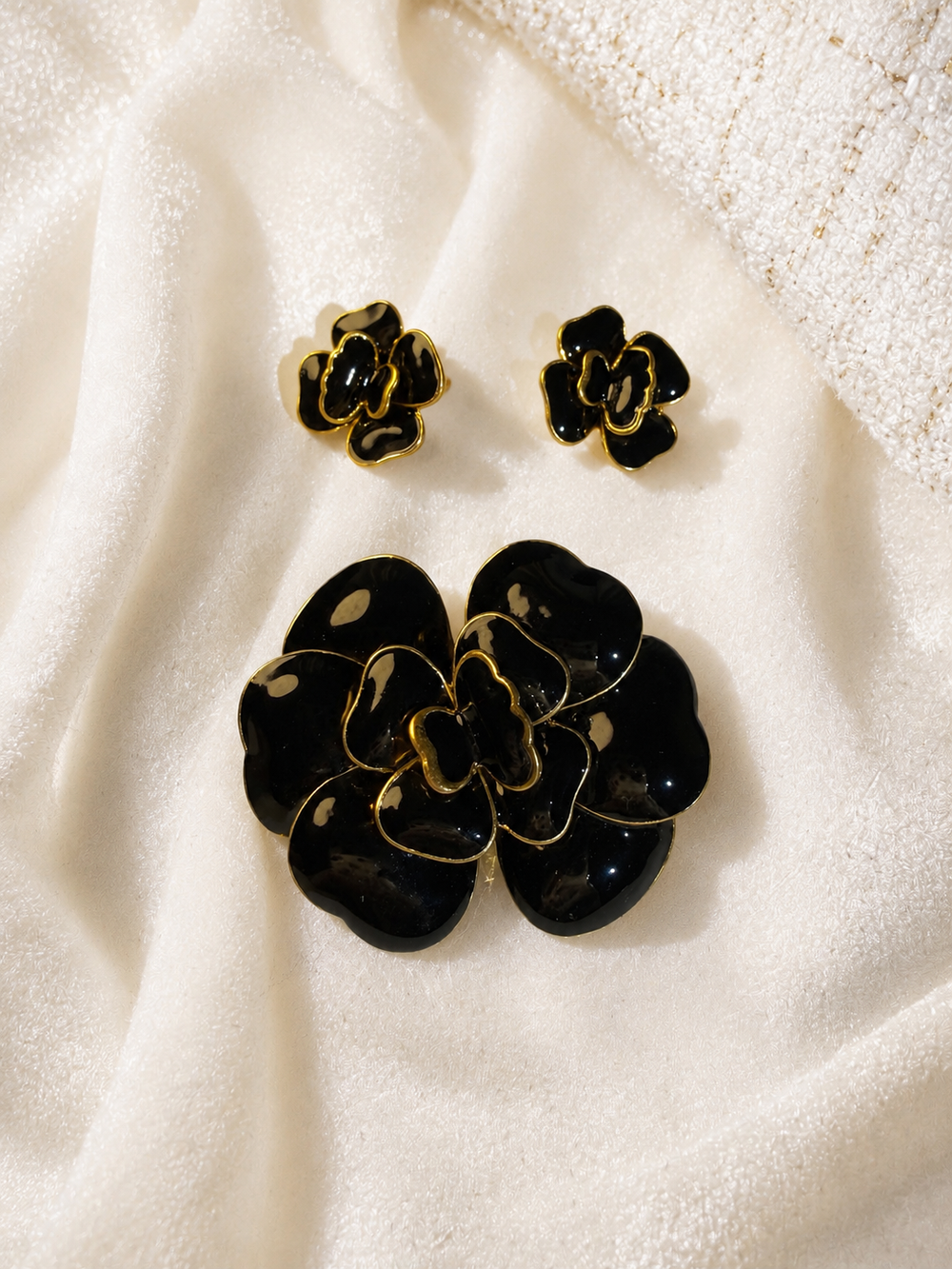 Gold-tone black enamel-style flower brooch and stud earrings set front view