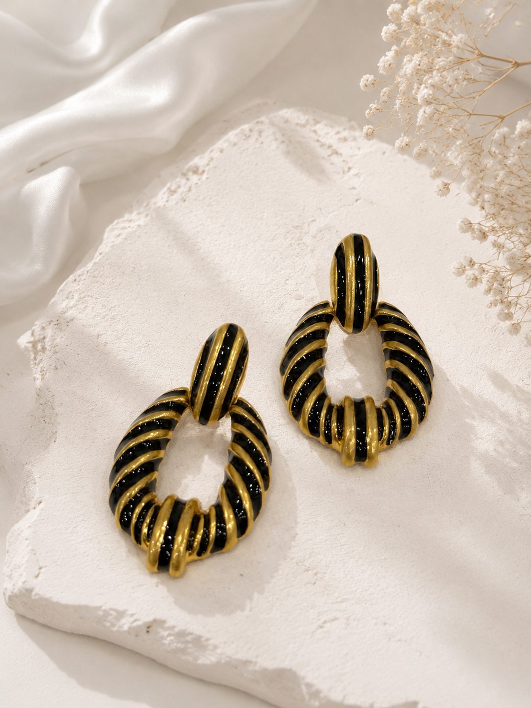 Gold-tone black enamel-style zebra stripe statement earrings detail view