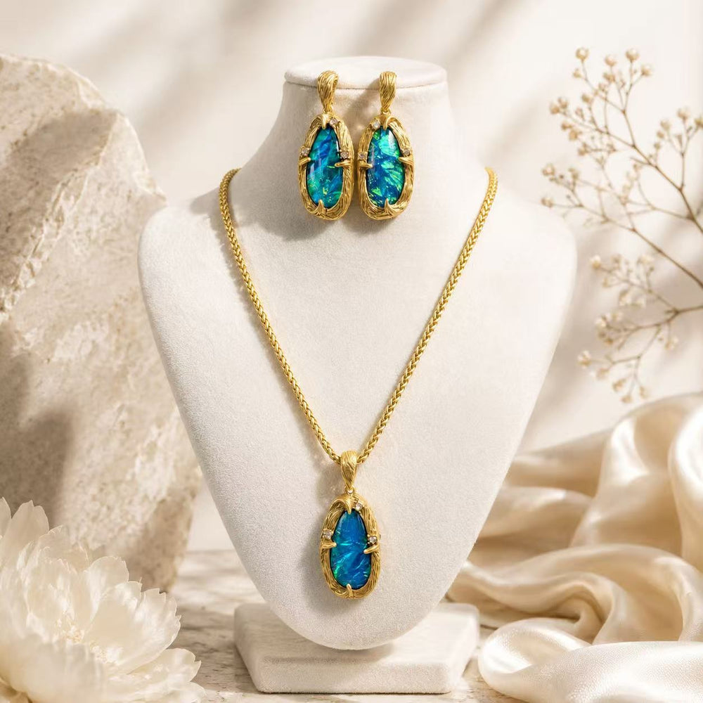 Gold-tone blue-green iridescent stone-style necklace and stud earrings set on a bust