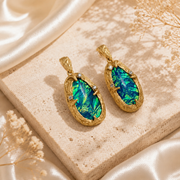 Gold-tone blue-green iridescent stone-style stud earrings and pendant necklace detail