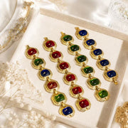 Gold-tone cabochon-style bracelet color options in red green and blue