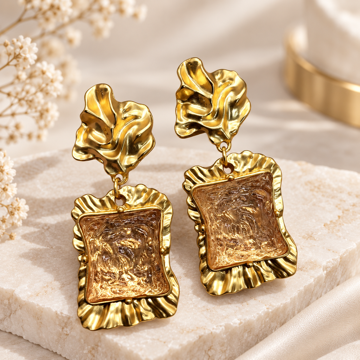 Gold-tone statement stud earrings with pink textured rectangular centers.