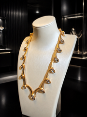 Gold-tone clear crystal-style statement necklace angled front view