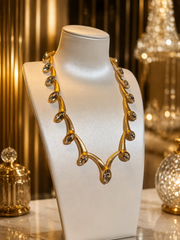 Gold-tone clear crystal-style statement necklace side front view