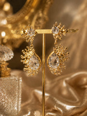 Gold-tone clear rhinestone-style teardrop stud earrings on display stand