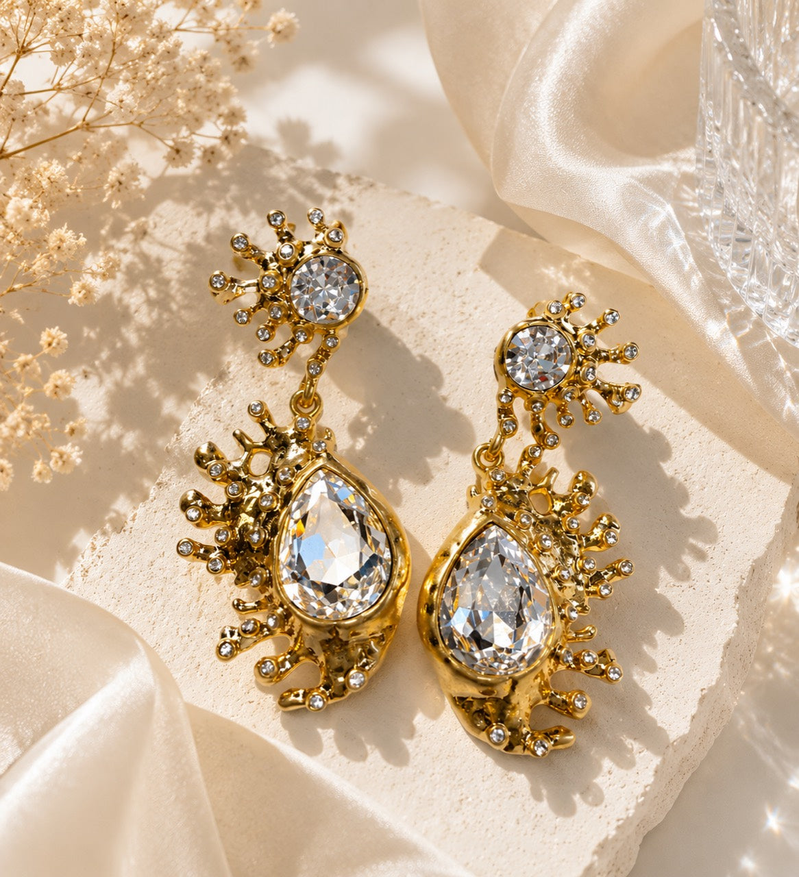 Gold-tone clear rhinestone-style teardrop stud earrings front view