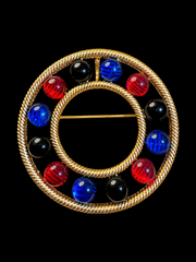 Gold-tone convertible circle cabochon-style brooch pendant front view with red blue and black accents
