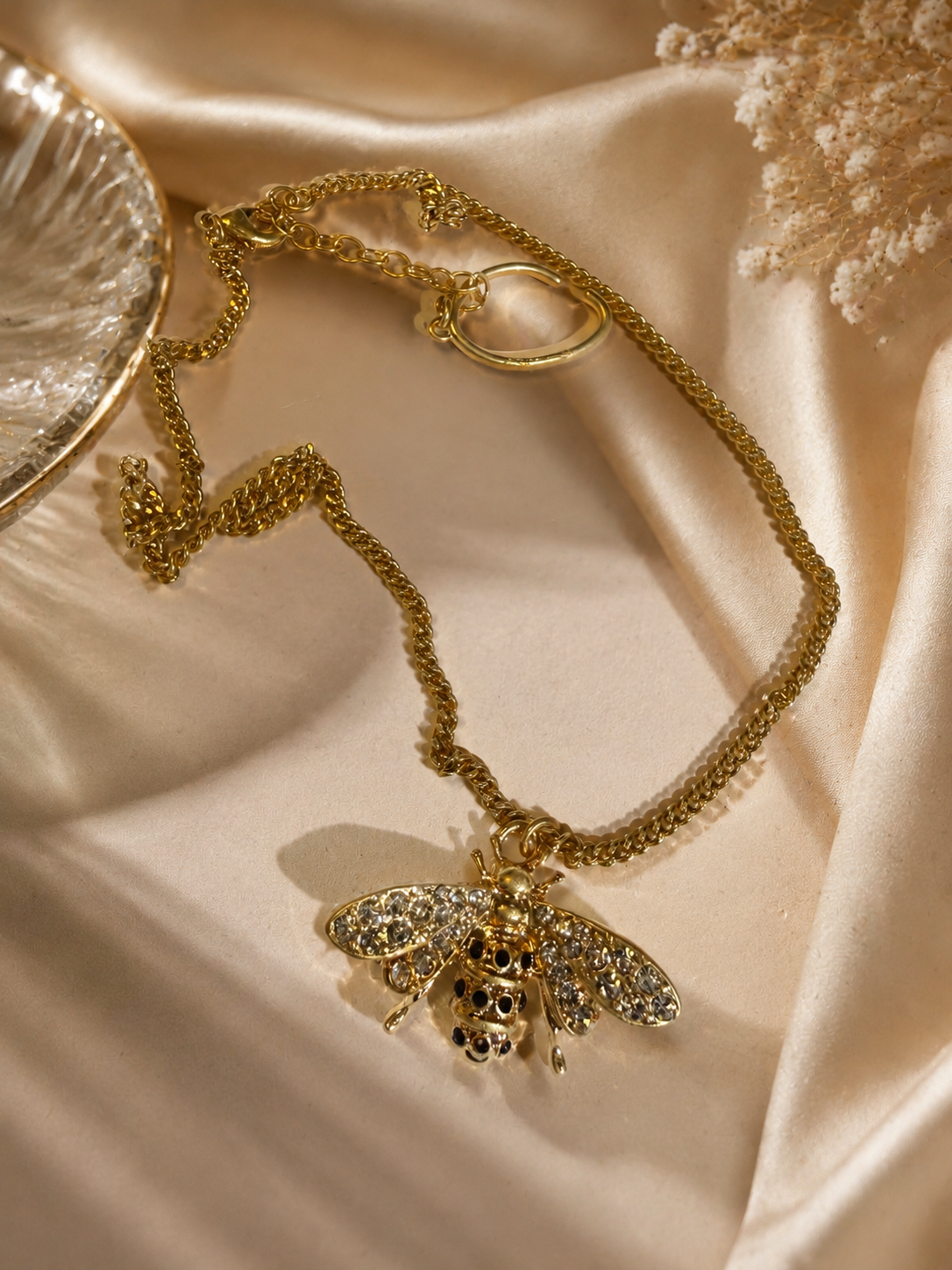Gold-tone bee pendant necklace clasp and chain detail