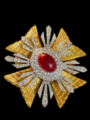 Gold-tone and silver-tone crystal-style cross statement brooch angled front view