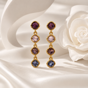 Purple gold-tone crystal-style four-stone drop stud earrings