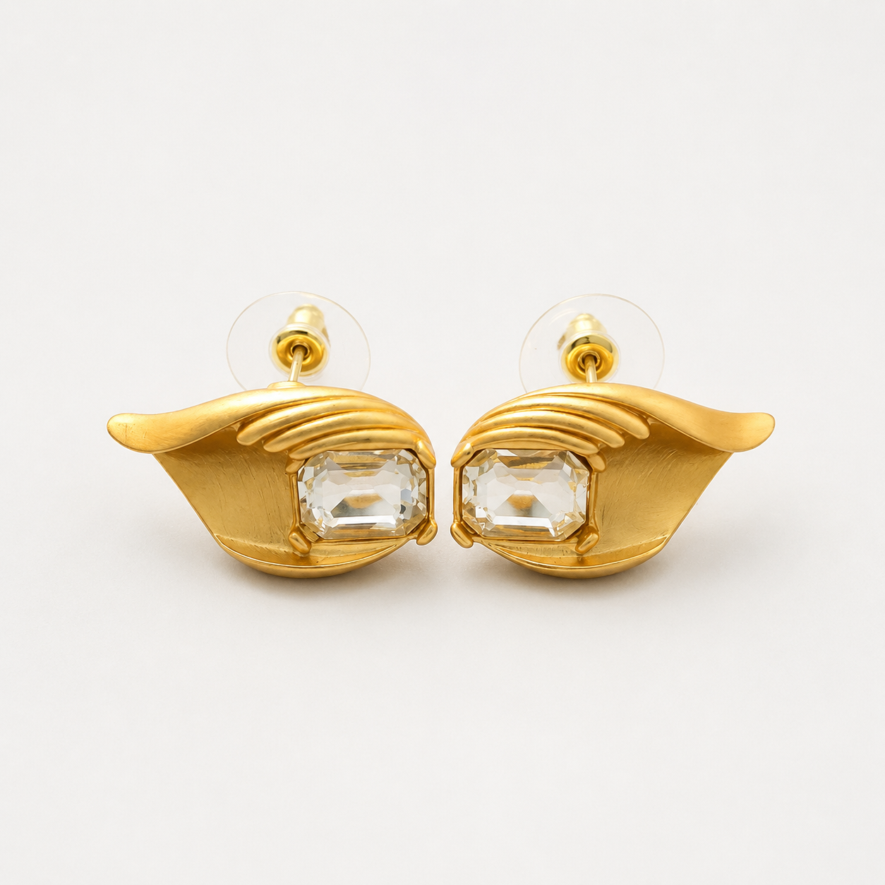 Gold-tone clear crystal-style leaf stud earrings pair