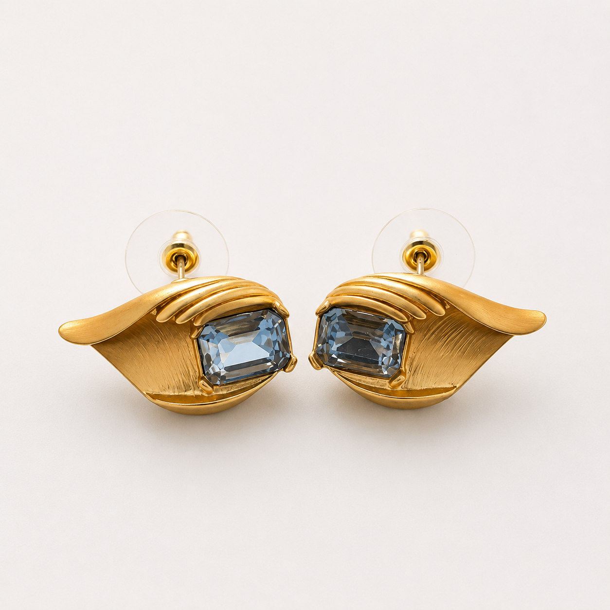 Gold-tone light blue crystal-style leaf stud earrings pair