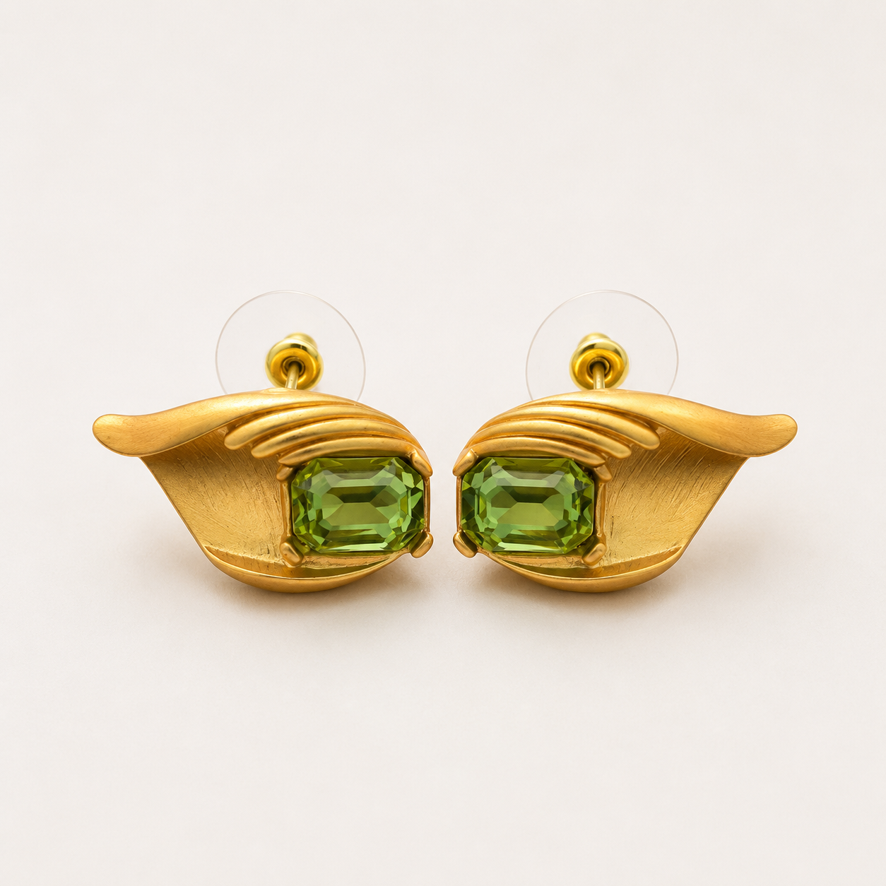 Gold-tone light green crystal-style leaf stud earrings pair
