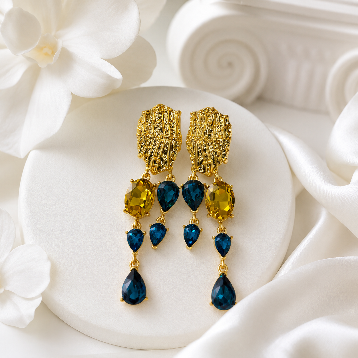 Blue crystal-style teardrop tassel earrings with gold-tone textured tops