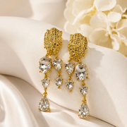 Clear crystal-style teardrop tassel earrings with gold-tone textured tops