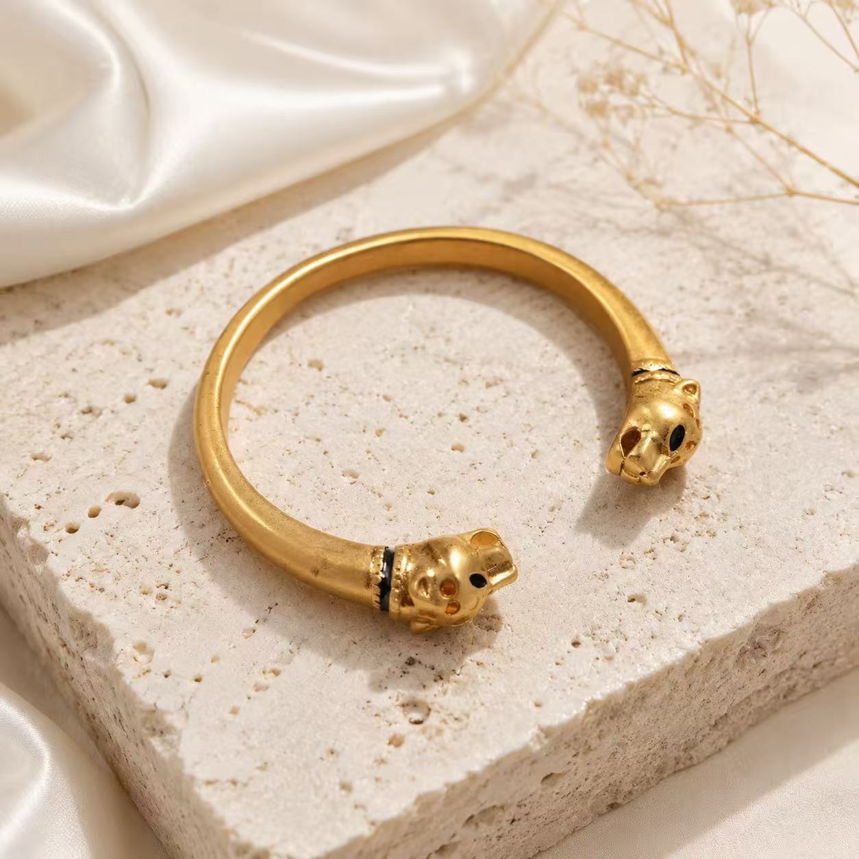 Gold-tone double leopard head open cuff bracelet angled view